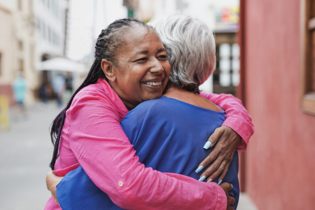 Elderly multiracial women hugging each other - Friendship, love